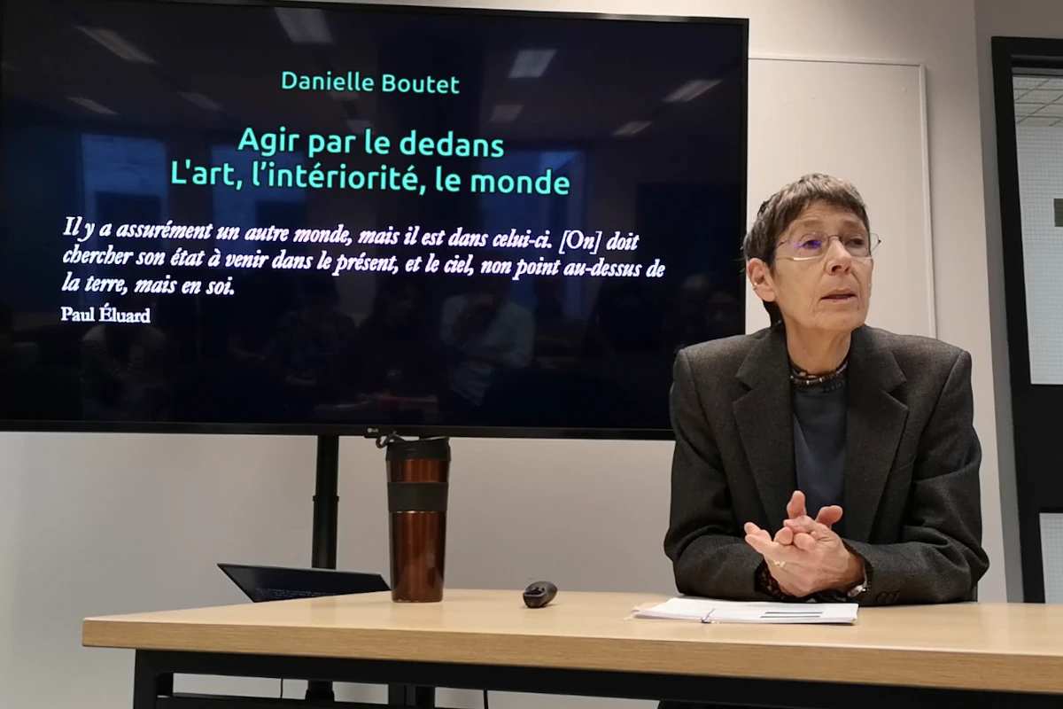 Danielle Boutet devant l'écran de présentation de sa conférence.